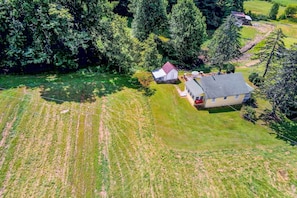 An aerial view of a rural property with a house, a barn, and surrounding fields. - Fish, Bike & Hike: Blue Ridge Cottage! (Bakersville)