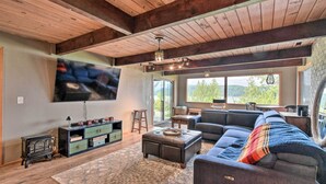 A spacious living room with a large sectional sofa, a fireplace, and a television mounted on the wall. - Deck & Sweeping Views: Family Union Home (Union)