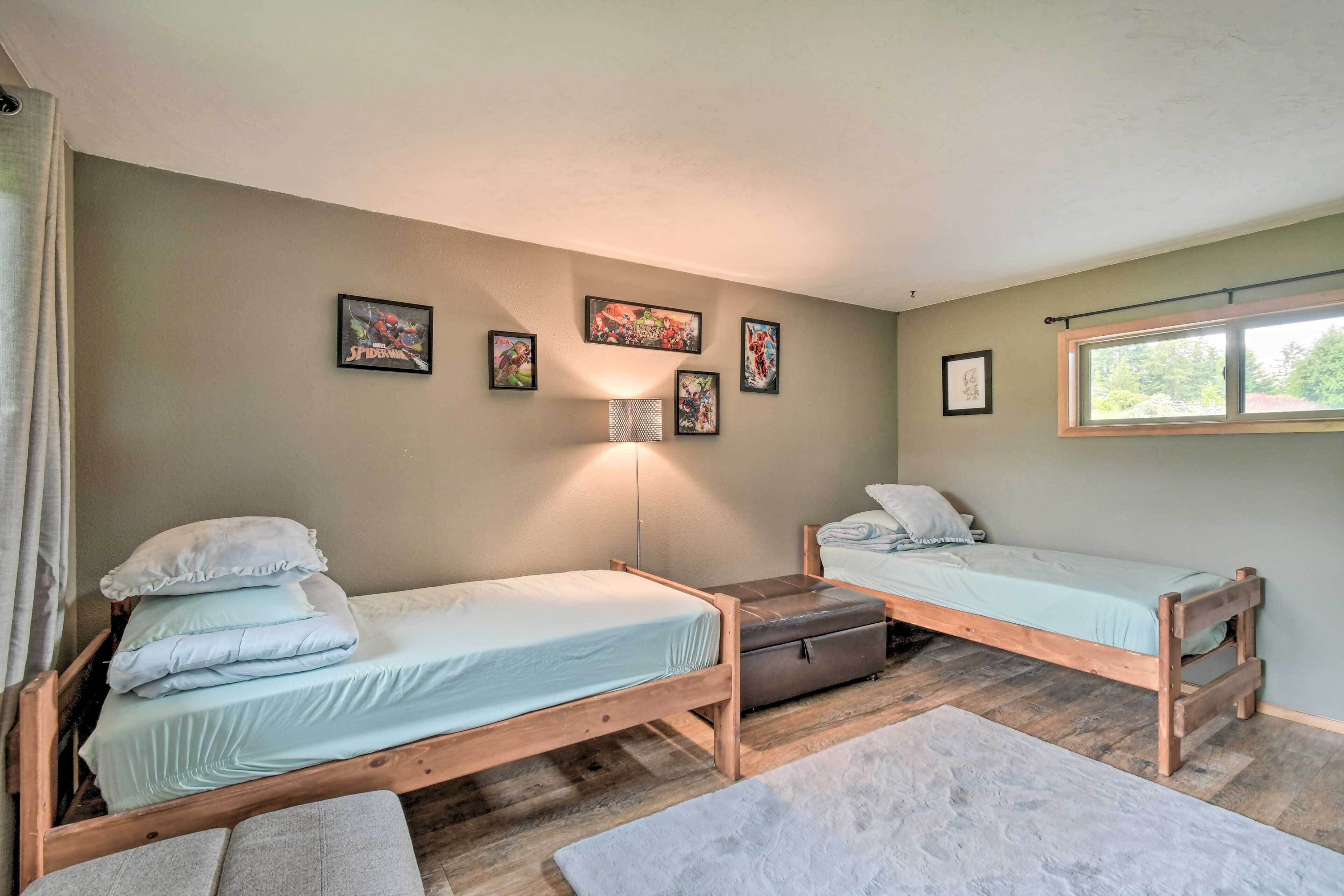 A room with two wooden beds, a small table, and a window.