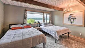 A bedroom with two beds, a large window with curtains, a chandelier, and a painting on the wall. - Deck & Sweeping Views: Family Union Home (Union)