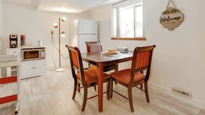 A dining area with a wooden table, four chairs, a white refrigerator, a microwave, a floor lamp, and a 'Welcome' sign on the wall. - Pet-friendly Minneapolis Apt Near Shops & Dining! (Spring Lake Park)