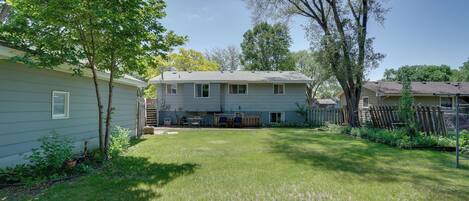 A house with a backyard, a small shed, and a wooden fence.
