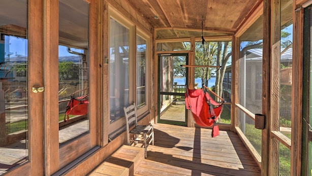A wooden deck with a hammock, a bench, and a view of the outdoors. - Waterside Belhaven House & Cottage w/ Porch & Dock (Belhaven)