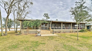 A rustic cabin with a covered porch, a small deck, and a grassy yard. - Waterside Belhaven House & Cottage w/ Porch & Dock (Belhaven)