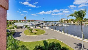 A marina with boats, a curved road, and a building with a red roof. - Waterfront Condo w/ Pool Access in Punta Gorda! (Punta Gorda)