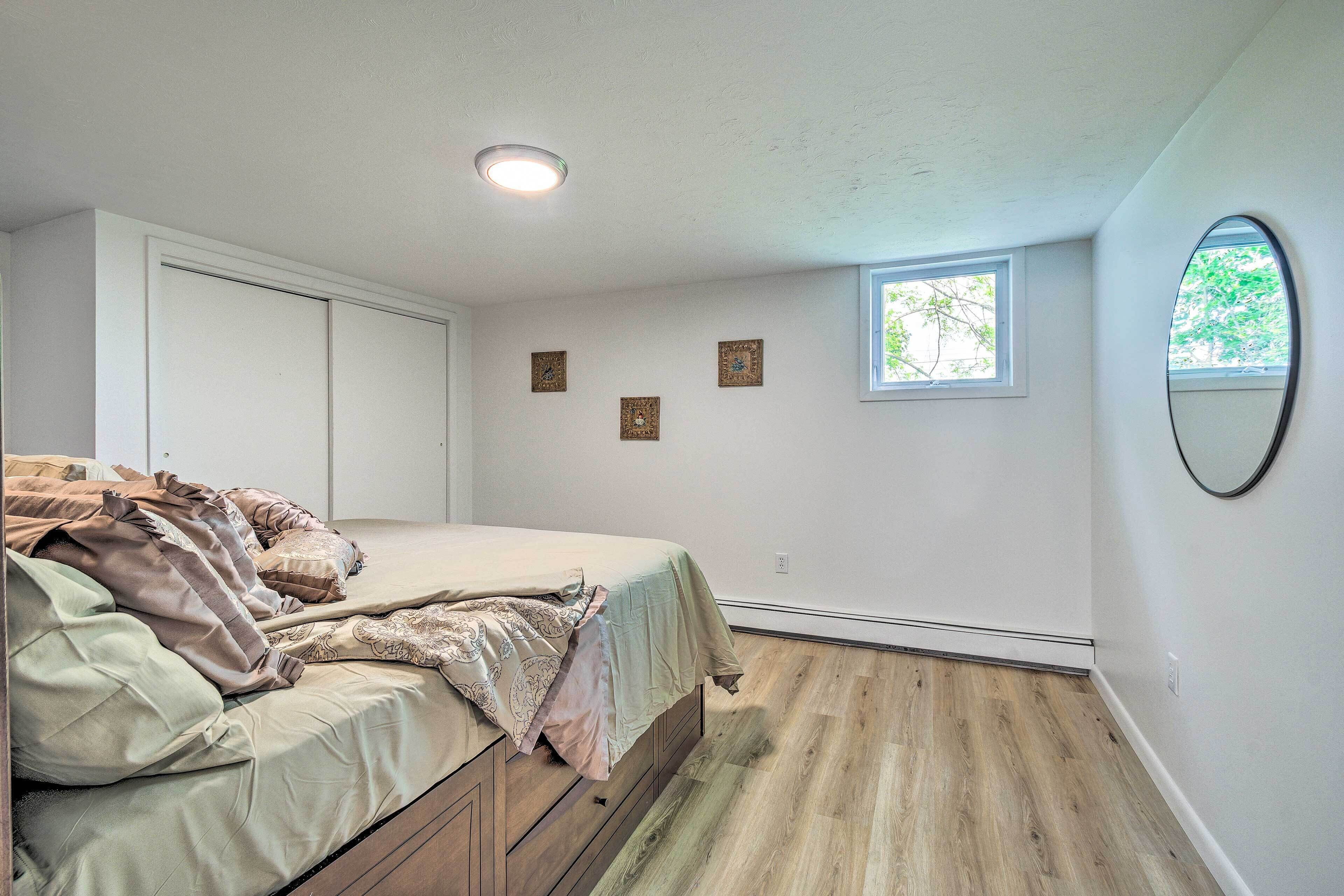 Une chambre à coucher avec un lit, une fenêtre et un miroir au mur.