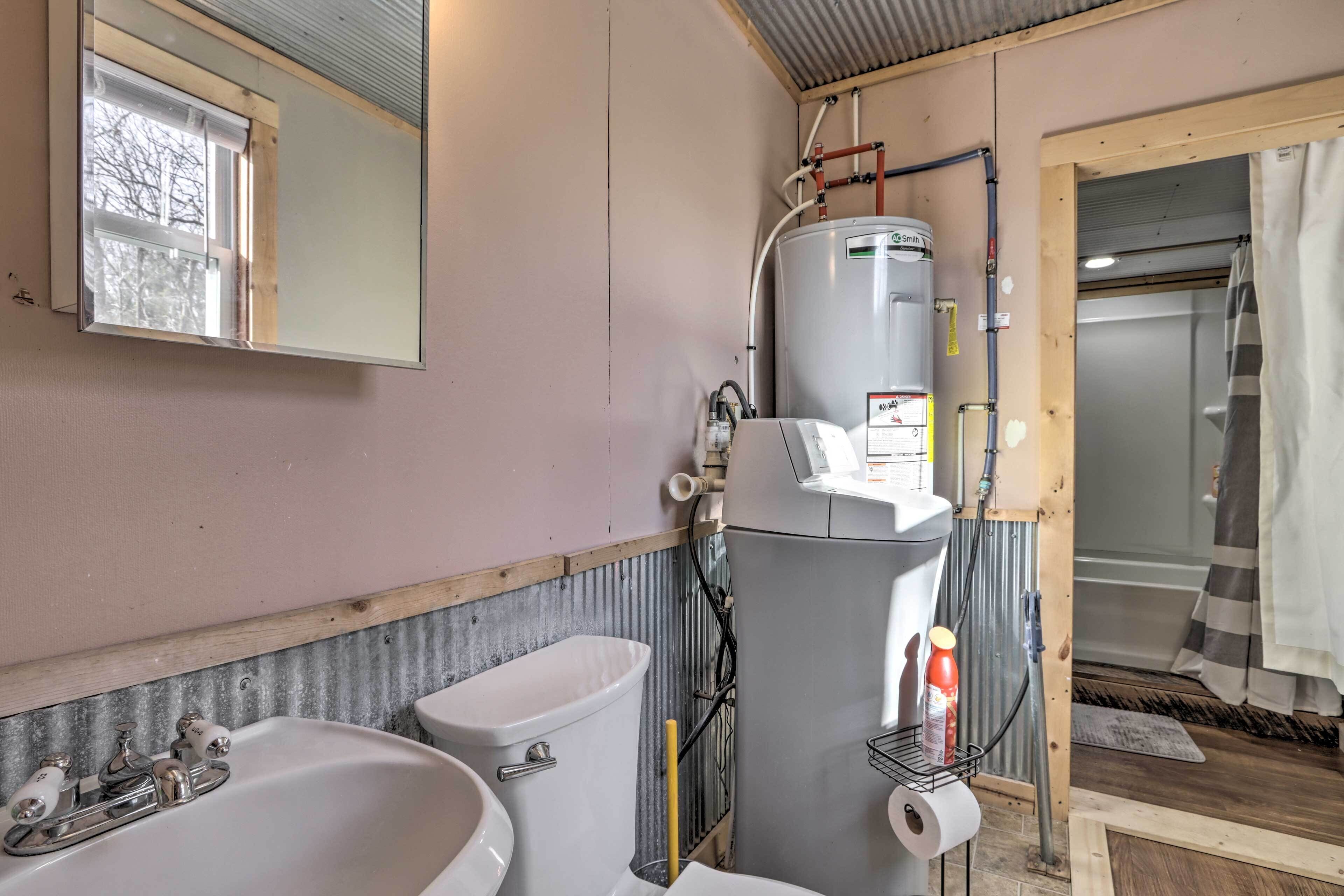 A bathroom with a toilet, sink, and a water heater.