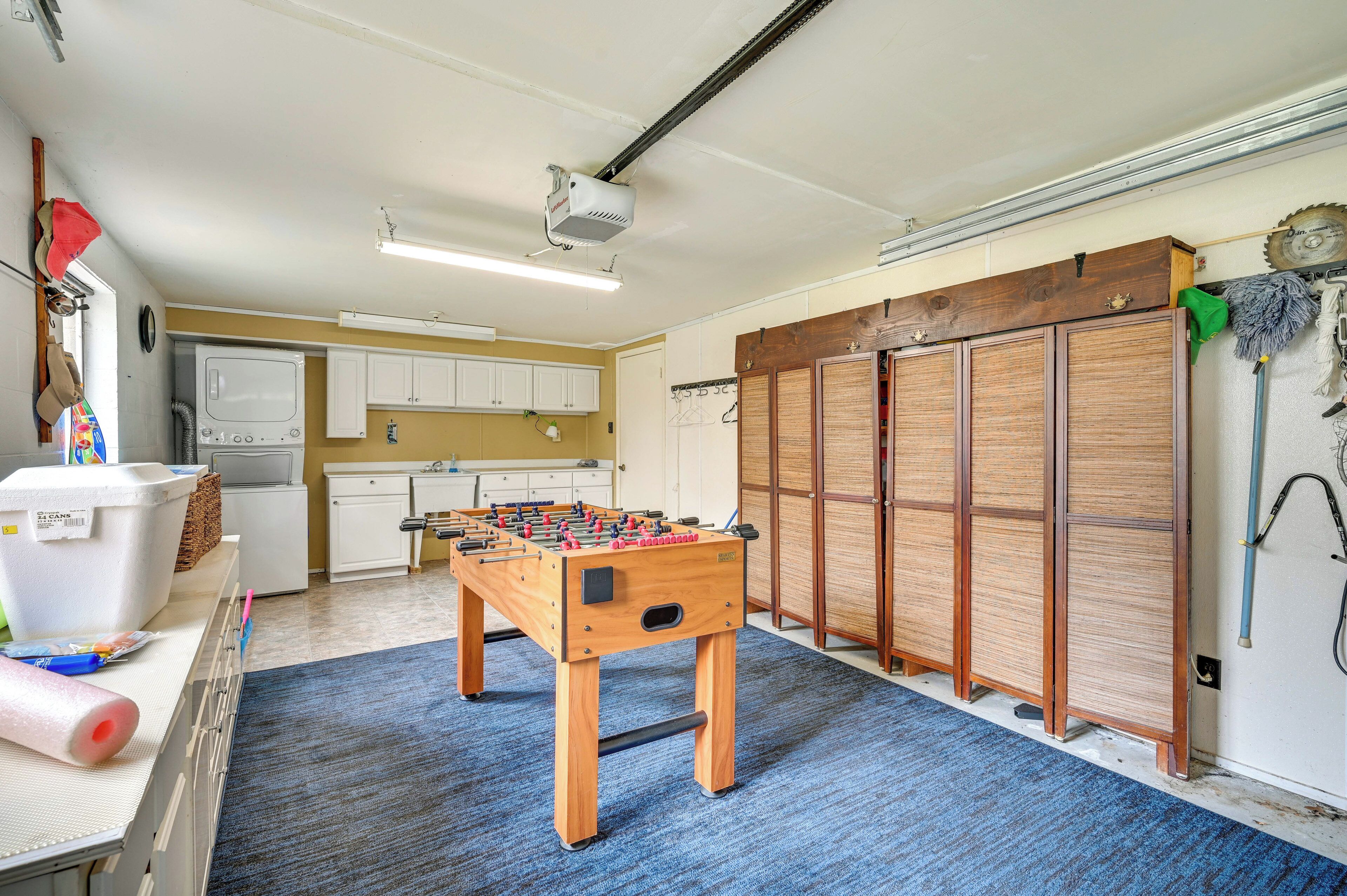 A room with a foosball table, a kitchenette, and a sliding door closet.