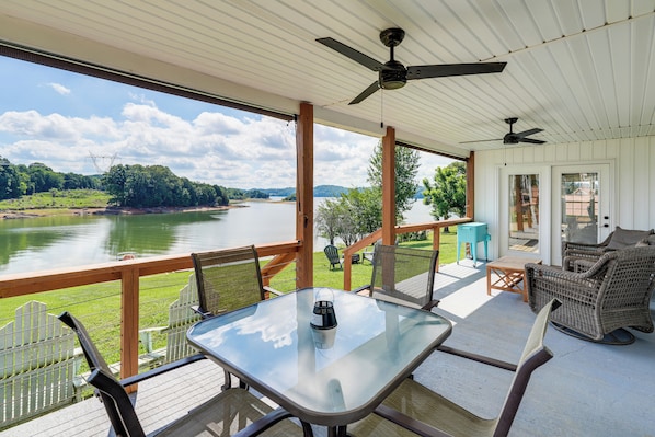 A covered outdoor deck with a table, chairs, and a view of a lake. - Cherokee Lake Home w/ Private Dock & Patio! (Mooresburg)