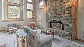 A cozy living room with a stone fireplace, large windows, and comfortable seating. - Historic Helena Retreat - Near Dtwn & Mt Helena! (Helena)