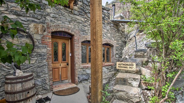 A stone building with a wooden door and windows, a wooden barrel, and a sign that reads "AUTHORIZED PERSONNEL ONLY". - Historic Helena Retreat - Near Dtwn & Mt Helena! (Helena)