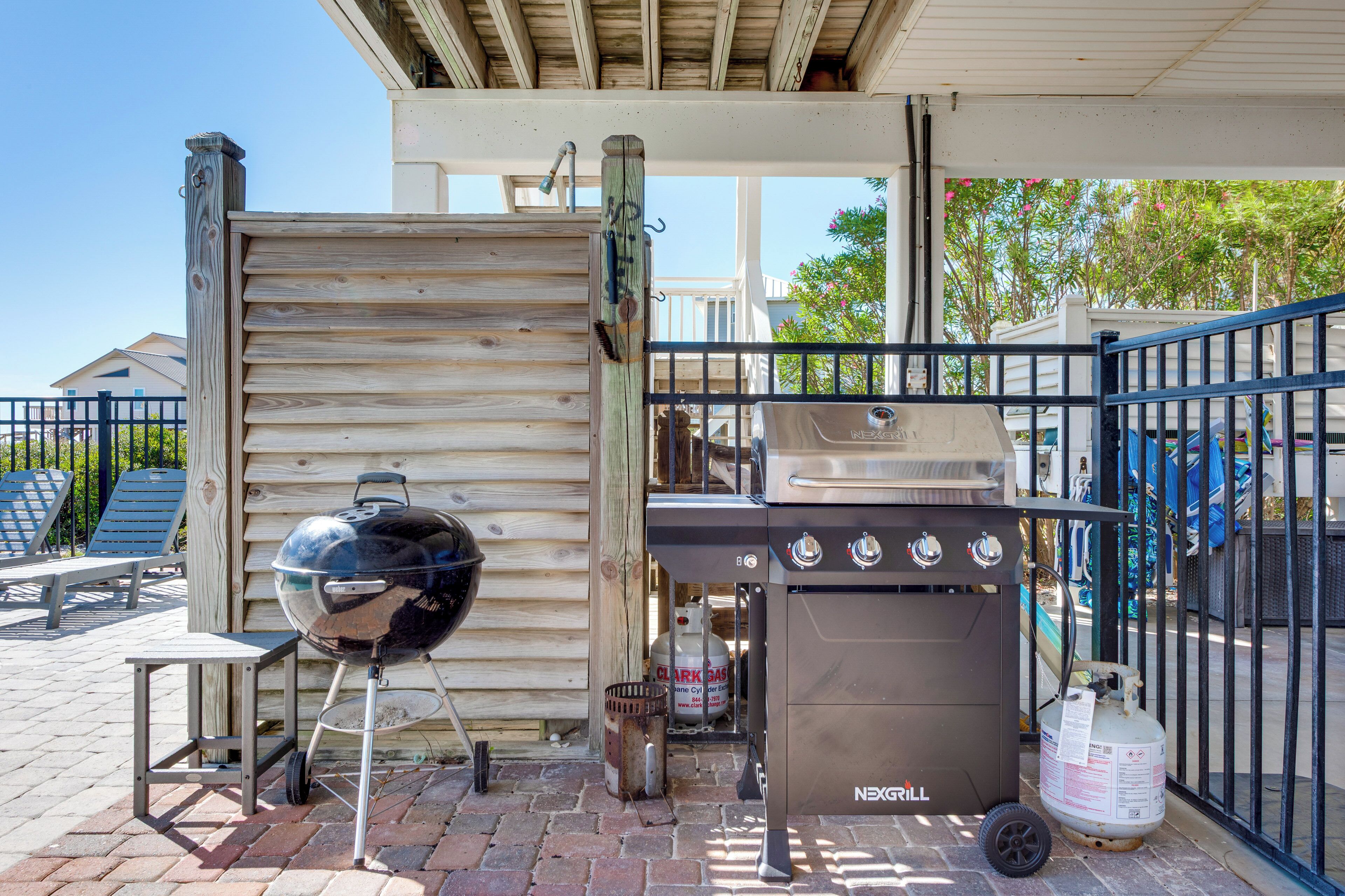 An outdoor barbecue area with a grill and a gas tank.