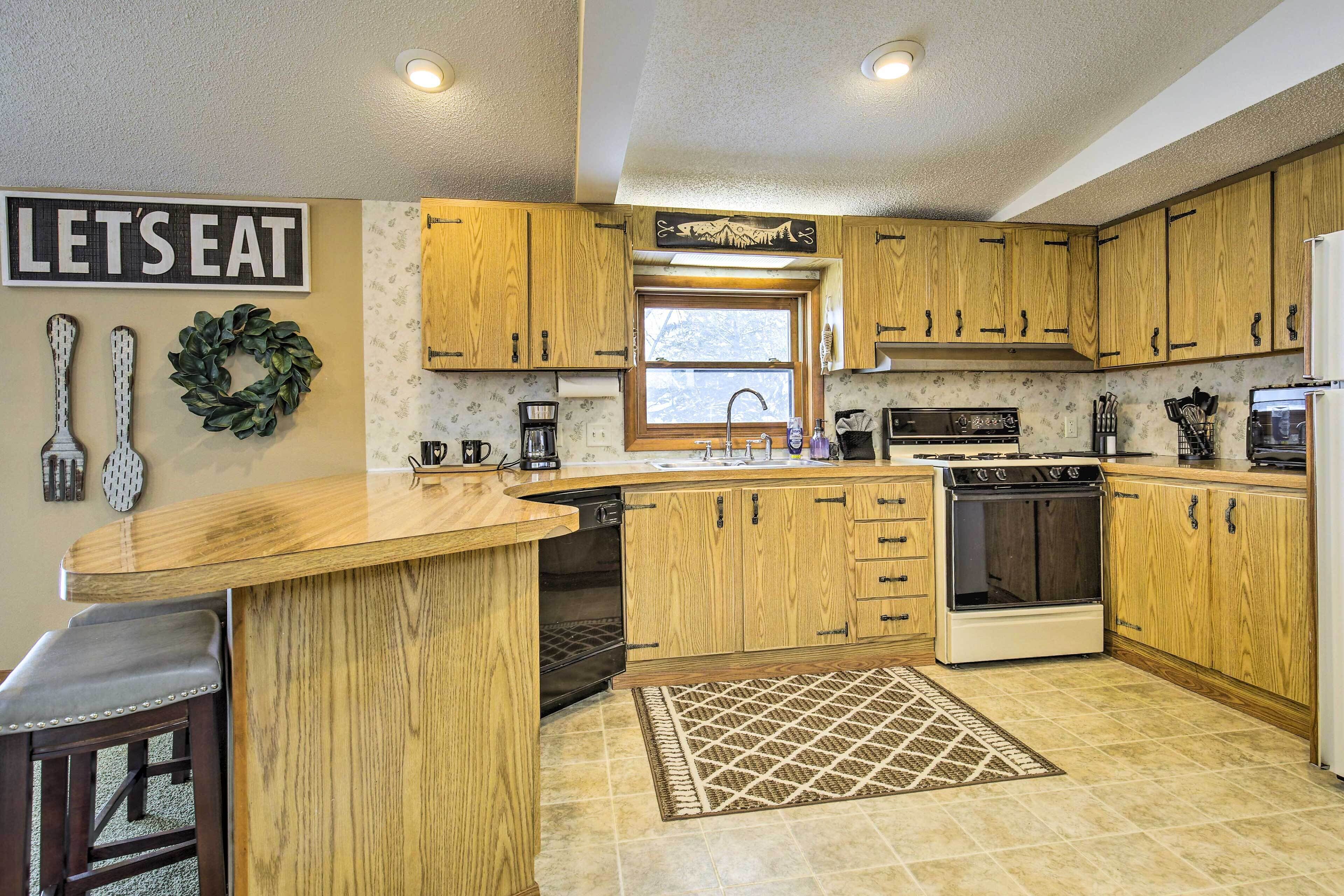 A kitchen with wooden cabinets, a built-in dishwasher, a stove, and a window.