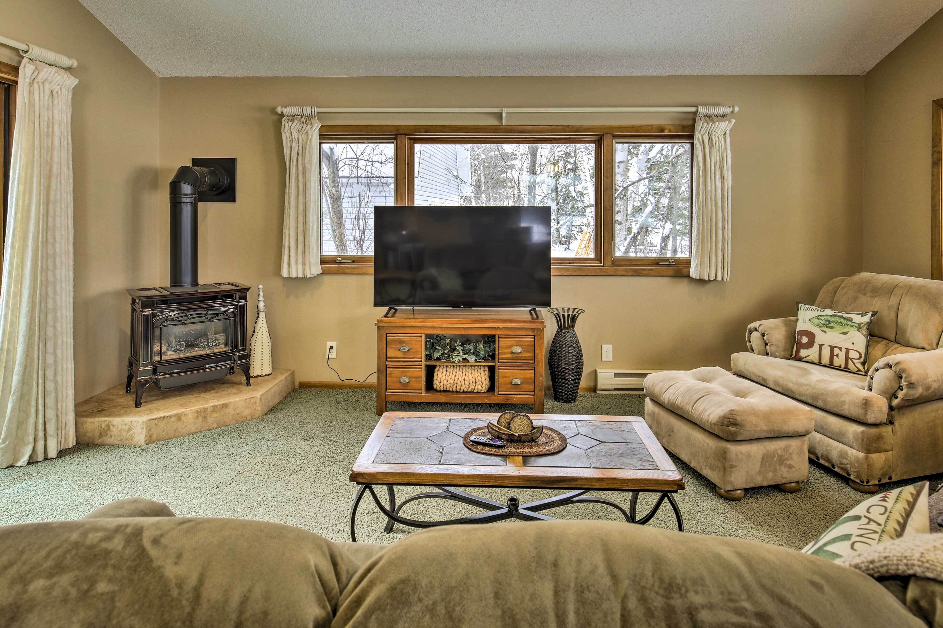 A cozy living room with a fireplace, a television, and comfortable seating.