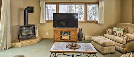 A cozy living room with a fireplace, a television, and comfortable seating.