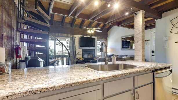 A kitchen with granite countertops, stainless steel sink, and white cabinetry. - Townhome w/ Mtn View - Walk to Brian Head Lifts! (Brian Head)