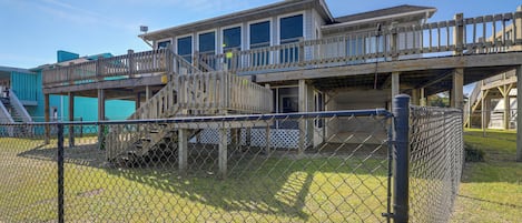 A two-story building with a wooden deck and a covered walkway.