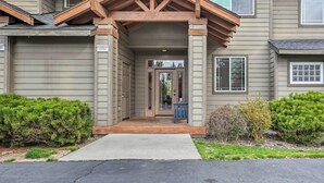 A two-story house with a covered front porch, a garage, and a well-maintained front yard with shrubs. - Charming Redmond Townhome w/ Resort Amenities (Redmond)