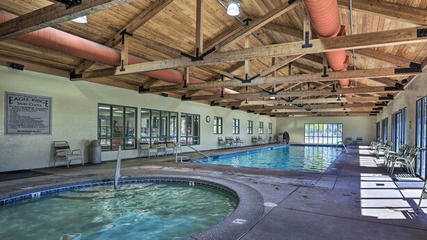 An indoor swimming pool with wooden beams and a hot tub, surrounded by windows and chairs. - Charming Redmond Townhome w/ Resort Amenities (Redmond)