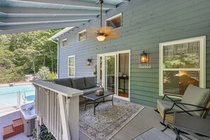 A covered outdoor area with a pool, a sofa, a table, and a chair. - Hot Tub, Fire Pit: Family-friendly Murphy Home (Murphy)
