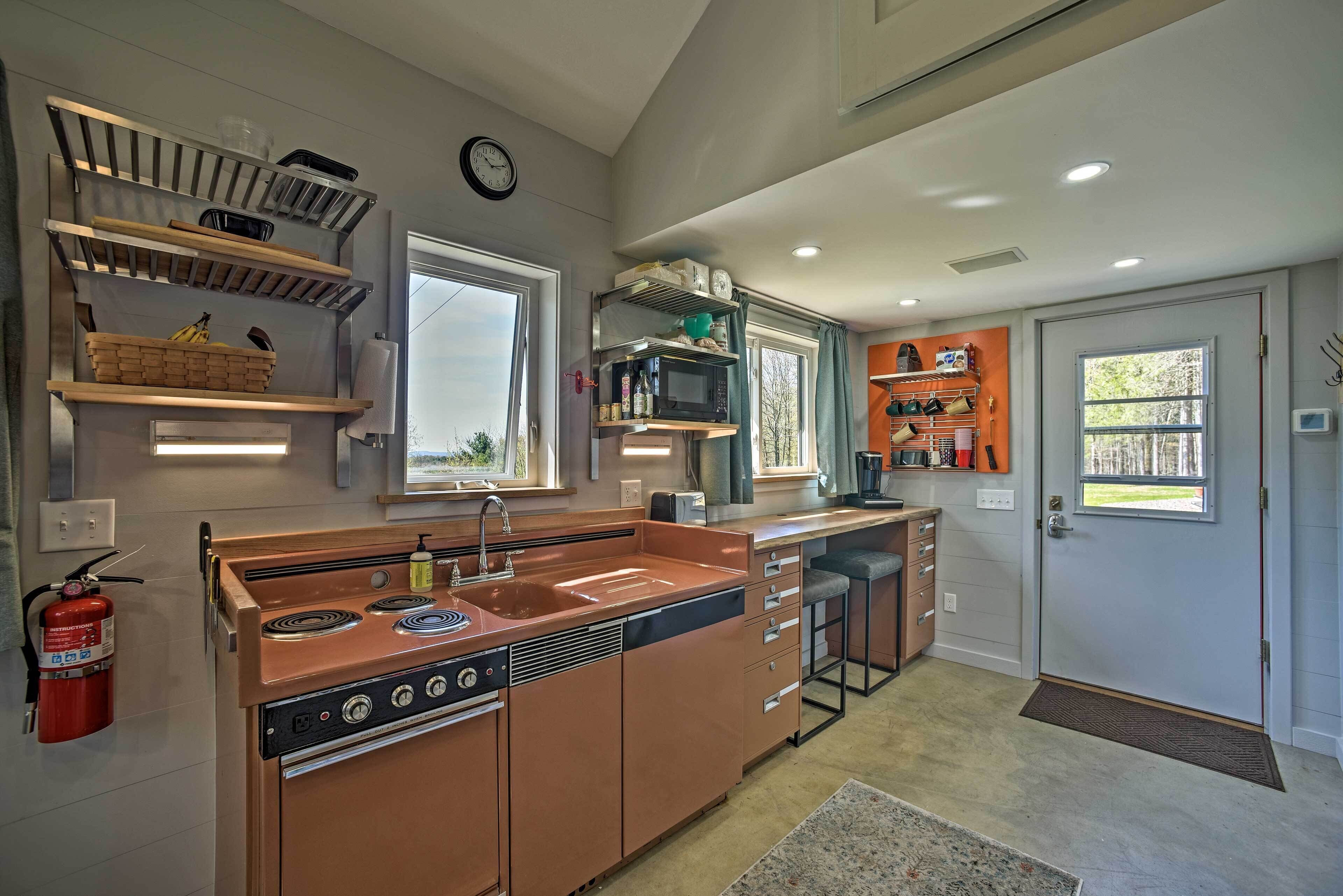 A modern kitchen with built-in appliances, a large window, and a door leading to a balcony.