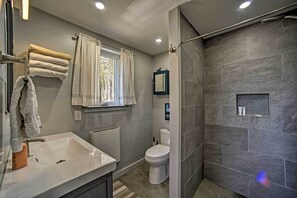 Un baño moderno con un lavamanos grande, inodoro y zona de ducha.