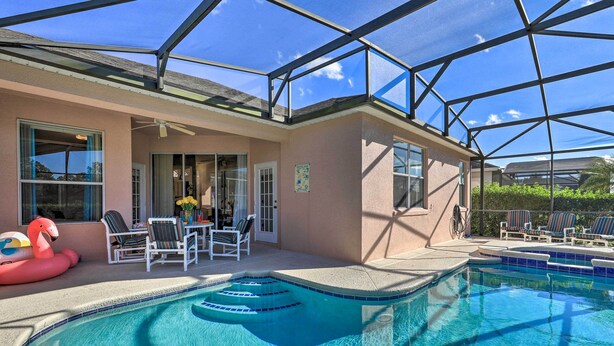 A swimming pool with a glass enclosure, lounge chairs, and a flamingo float. - Family-friendly Escape w/ Smart TVs & Themed Rooms (Davenport)
