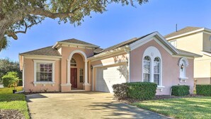 A single-story house with a garage, a front door, and a driveway. - Family-friendly Escape w/ Smart TVs & Themed Rooms (Davenport)