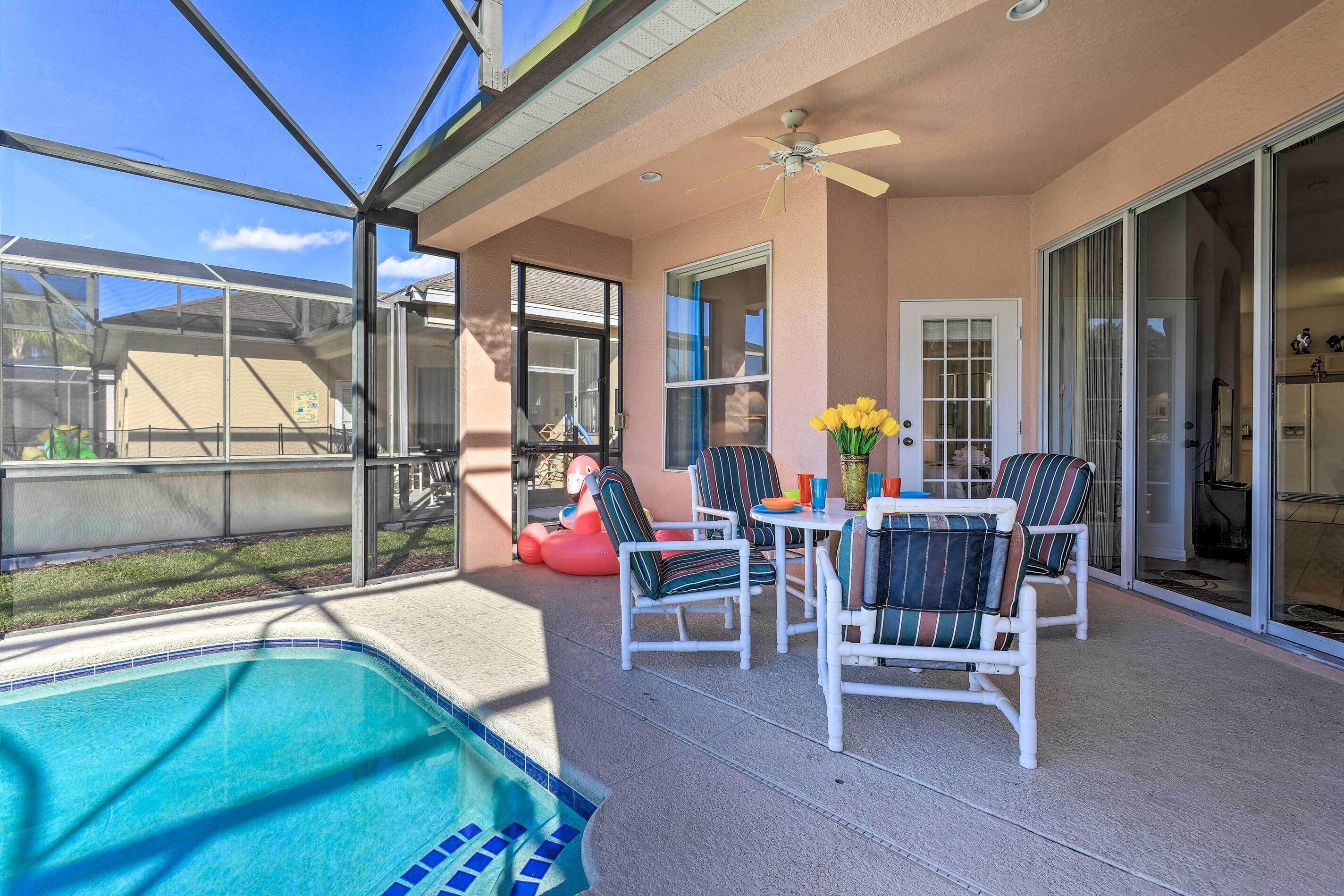 A covered patio with a pool, outdoor seating, and a sliding glass door leading to a kitchen.