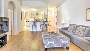 A modern living room with a grey sofa, patterned ottoman, and a ceiling fan. - Family-friendly Escape w/ Smart TVs & Themed Rooms (Davenport)