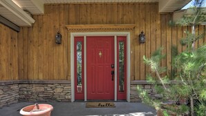 A red door with a doormat, two lanterns, and a potted plant. - Idyllic Idaho Falls Retreat w/ River Views! (Rigby)