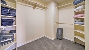A walk-in closet with shelves for folded clothes, a hanging rod, and a vacuum cleaner. - Idyllic Idaho Falls Retreat w/ River Views! (Rigby)