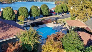 A residential area with a swimming pool, trees, and a view of a lake. - 'lakeview Blue Oasis' in Hot Springs: Lake Access (Hot Springs)