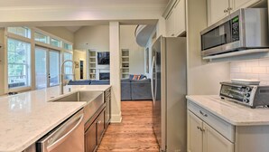 A modern kitchen with stainless steel appliances, a marble countertop, and a view into the living area. - 2 Mi to Dtwn: Home in Noda District Near Unc! (Charlotte)