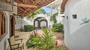 A courtyard with a tiled floor, a wooden pergola, a bench, and potted plants. - Tropical Sayulita Condo w/ Patio & Beach Access! (Sayulita)