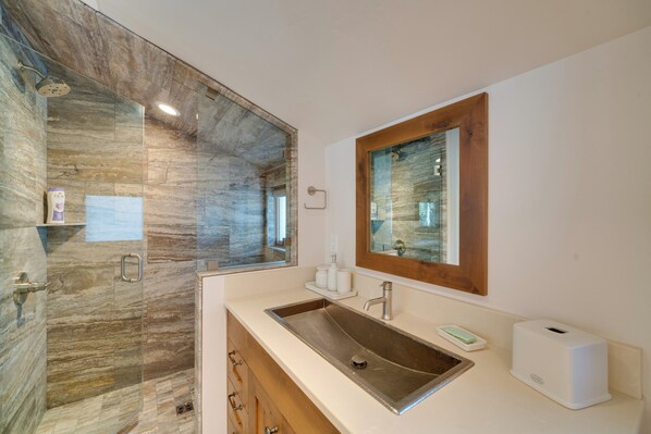A bathroom with a large mirror, a sink, a shower, and a wooden cabinet. - Custom Ski-in/out Chalet With Hot Tub & Wet Bars! (Big Sky)