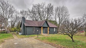 A single-story building with a dark exterior, a chimney, and a small porch. - Updated Hendersonville Home ~ 3 Mi to Lake! (Hendersonville)