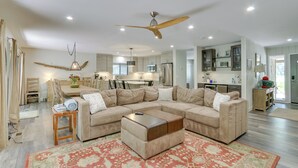 A spacious living room with a large L-shaped sectional sofa, a wooden coffee table, and a ceiling fan. - 1 Mi to Harbour Town: Sea Pines Resort Home (Hilton Head Island)