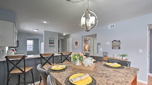 A dining area with a large table, black chairs, and a chandelier. - Updated Branson Condo w/ Indoor Pool Access! (Branson)