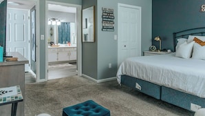 A bedroom with a bed, a dresser, a vanity, and a mirror. There is a sign on the wall with text. - Updated Branson Condo w/ Indoor Pool Access! (Branson)