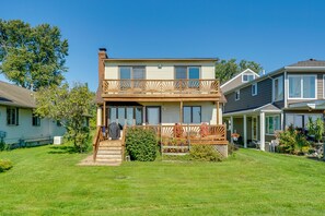 A two-story house with a balcony, a front porch, and a well-maintained lawn.