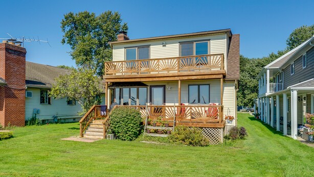 A two-story house with a front porch, a staircase, and a small garden area. - Anchor Bay Getaway on Lake St Clair With Dock! (New Baltimore)