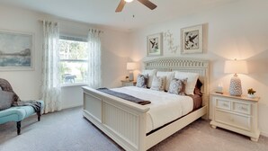 A bedroom with a bed, a nightstand, a ceiling fan, and a window with curtains. - Beautiful Port St Lucie Home w/ Hot Tub! (Port Saint Lucie)