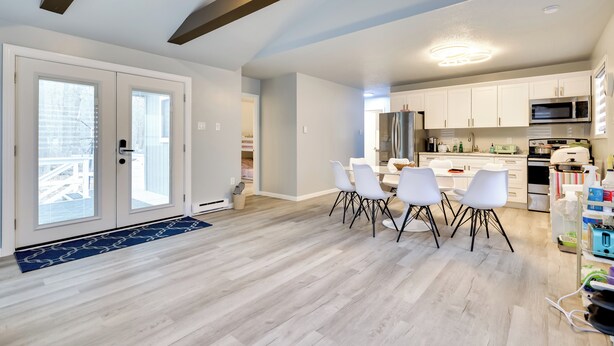 A modern kitchen with white cabinets, a stainless steel refrigerator, and a microwave. - 8 Mi to Tobyhanna State Park: Poconos Home! (Tobyhanna)
