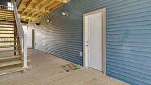 A covered wooden deck with a white door and a small window. - Brownsville Vacation Rental Near National Park! (Brownsville)