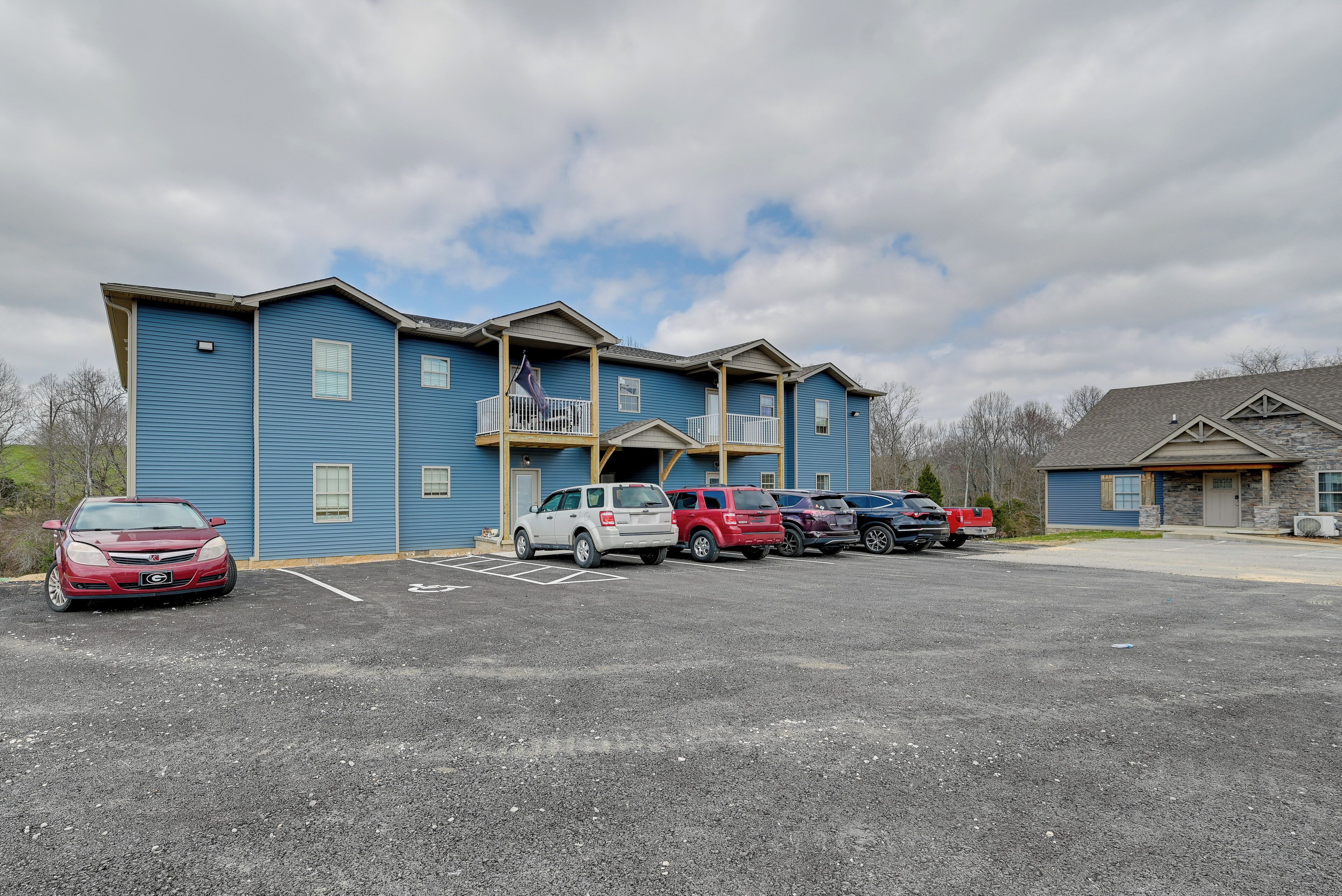 A multi-story building with a parking lot in front.