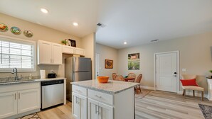 A modern kitchen with white cabinetry, a granite countertop, and a built-in island. - Brownsville Vacation Rental Near National Park! (Brownsville)