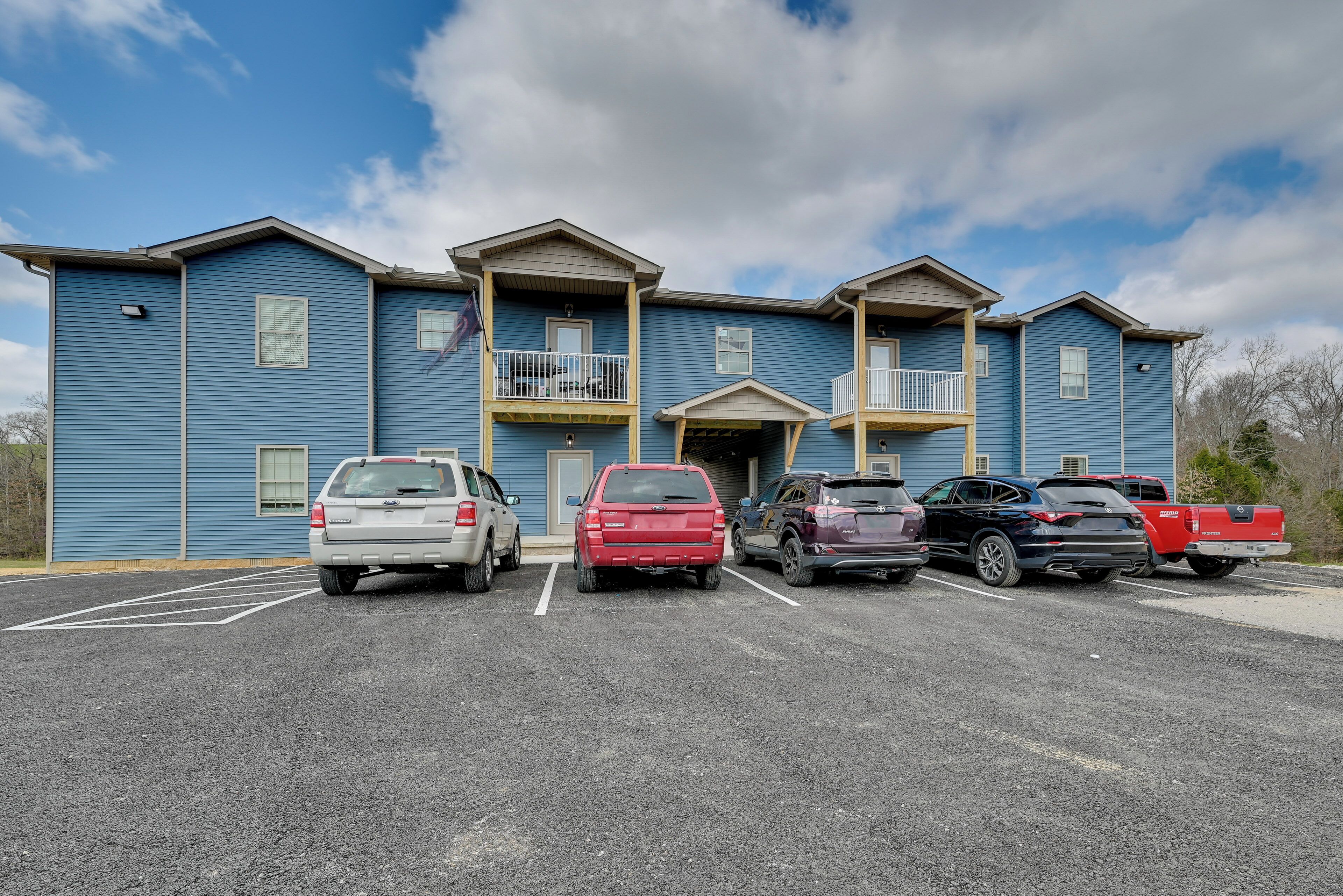 A multi-story building with a parking lot in front.