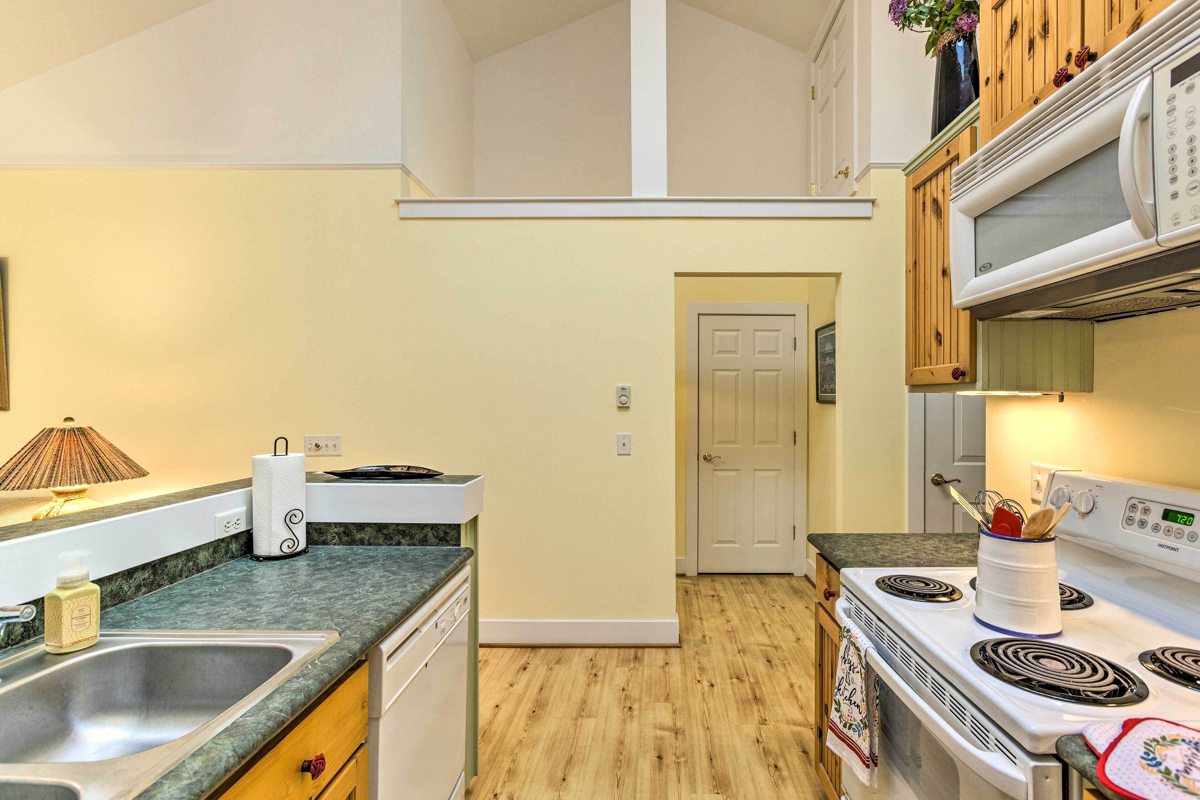 A kitchen with a sink, stove, and cabinets.