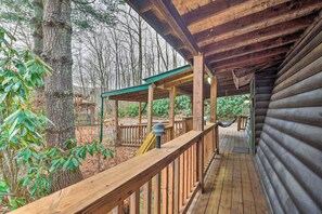 A wooden deck with a railing, a hammock, and a covered area with a green roof. - Deck & Private Hot Tub! Maggie Valley Mtn Cabin (Maggie Valley)
